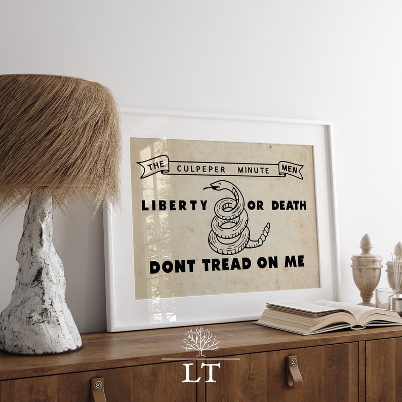 May include: A framed print with a vintage aesthetic featuring a coiled snake with the text "The Culpeper Minute Men Liberty or Death Don't Tread On Me".