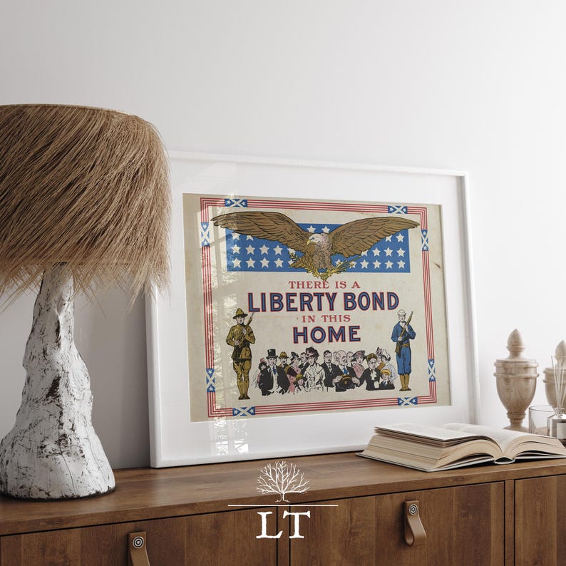 May include: Framed vintage poster with the text "THERE IS A LIBERTY BOND IN THIS HOME." The poster features an eagle, soldiers, and a crowd of people. A lamp with a textured shade and a decorative wooden cabinet are in the foreground.