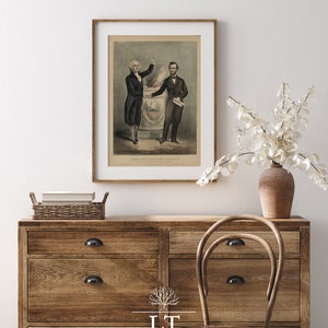 May include: A framed print of a historical illustration depicting George Washington and Abraham Lincoln standing together. The image shows Washington pointing to a burning torch and Lincoln holding a document. The text below the image reads "WASHINGTON AND LINCOLN."