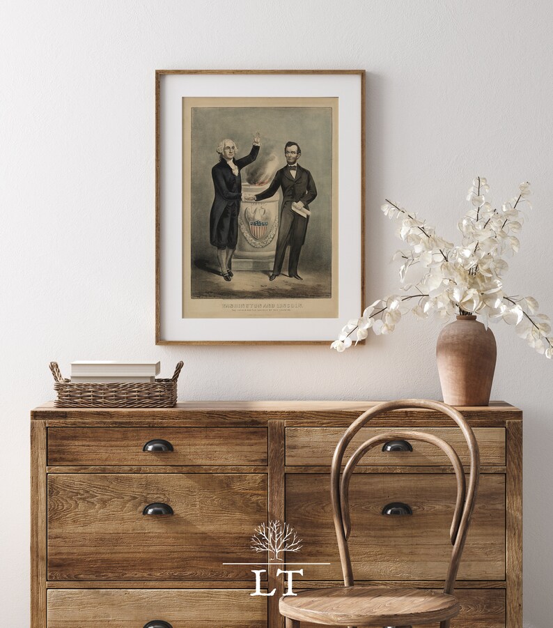 May include: A framed print of a historical illustration depicting George Washington and Abraham Lincoln standing together. The image shows Washington pointing to a burning torch and Lincoln holding a document. The text below the image reads "WASHINGTON AND LINCOLN."