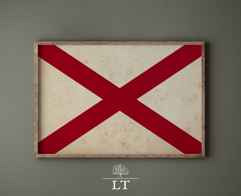 Puede incluir: Una impresi&oacute;n enmarcada de la bandera de Alabama. La bandera es blanca con una cruz roja en el centro. El marco es de madera y tiene un aspecto desgastado.