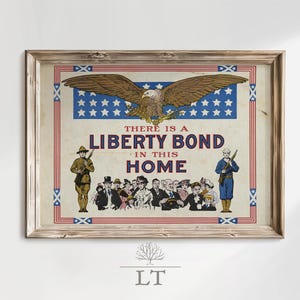 May include: Framed vintage print with a patriotic theme. The artwork features a bald eagle above a banner with stars and the text "THERE IS A LIBERTY BOND IN THIS HOME." Soldiers and a crowd of people are also depicted.