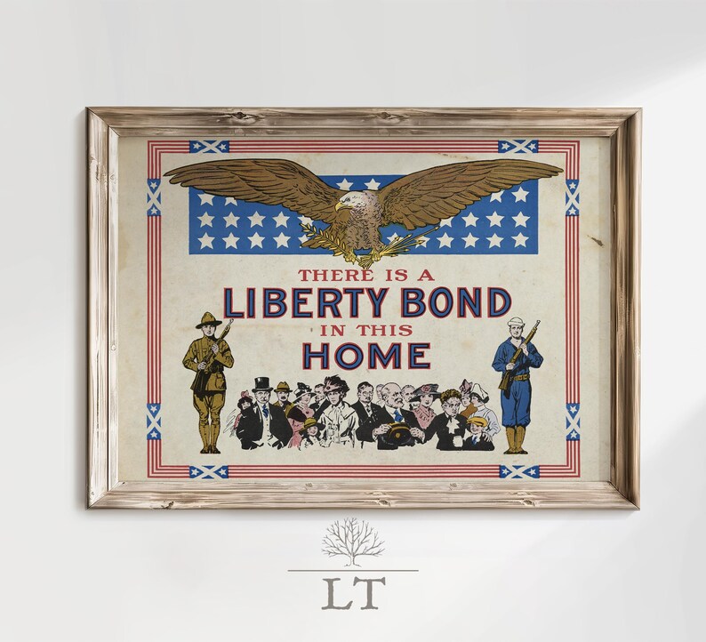 May include: Framed vintage print with a patriotic theme. The artwork features a bald eagle above a banner with stars and the text "THERE IS A LIBERTY BOND IN THIS HOME." Soldiers and a crowd of people are also depicted.
