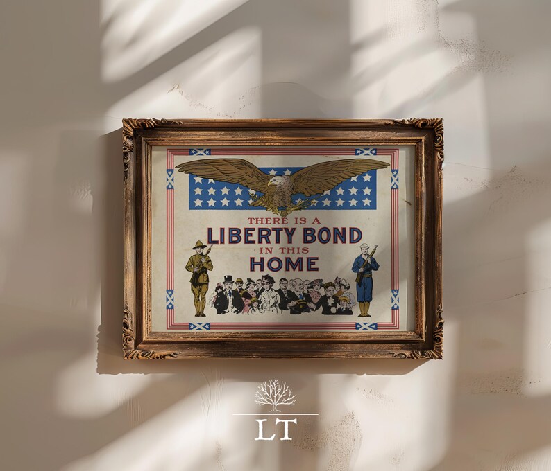 May include: Framed vintage print with a patriotic theme. The artwork features an eagle, stars, and the text "THERE IS A LIBERTY BOND IN THIS HOME." Soldiers and a crowd of people are also depicted. The frame is ornate and brown.