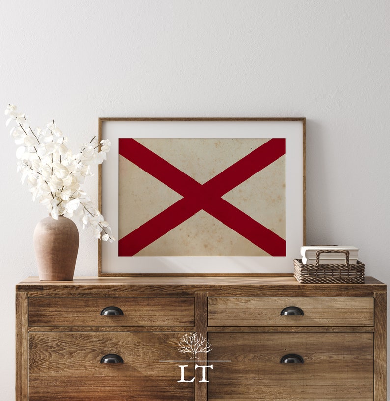 Puede incluir: Una impresi&oacute;n enmarcada de una cruz roja sobre un fondo blanco. La impresi&oacute;n est&aacute; colgada en una pared blanca sobre una c&oacute;moda de madera con dos cajones.
