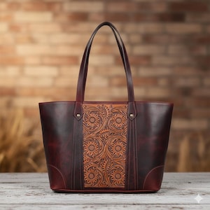 Könnte beinhalten: Burgunderfarbene Ledertasche mit floralem Sonnenblumenmuster. Die Tasche hat ein Mittelteil mit geprägten Sonnenblumen und eine satte, dunkelburgunder Farbe. Sie hat zwei Griffe und eignet sich zum Tragen von Gegenständen.