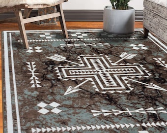 May include: A teal and brown area rug with a geometric pattern featuring arrows and a cross design. The rug has a white border.