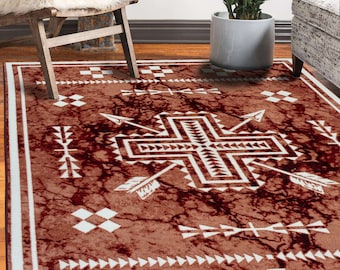 May include: A brown and white area rug with a geometric pattern of arrows and squares. The rug has a distressed, vintage look.