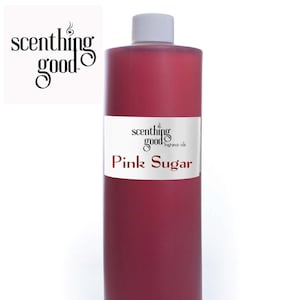 May include: A tall, cylindrical bottle filled with a vibrant pink liquid. The bottle has a white cap and a white label with the text "scenthing good fragrance oils" and "Pink Sugar". The logo "scenthing good" is in the upper left corner.