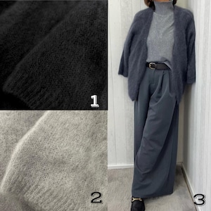 May include: A three-panel image showcasing a black, textured fabric sample, a light gray fabric sample, and a woman wearing a gray turtleneck, a dark gray cardigan, and wide-leg pants. The outfit is accessorized with a black belt and loafers.