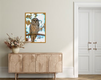 May include: A framed print of a barred owl perched on a branch. The owl has brown and white feathers and yellow eyes. The background is a blurred image of trees and leaves.