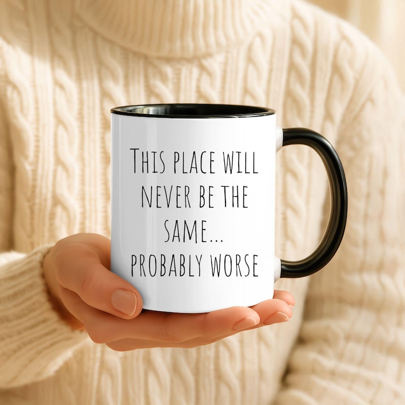 May include: A white ceramic mug with a black handle and rim, featuring the black printed text: This place will never be the same... probably worse. The mug has a cylindrical shape and a smooth finish, designed for holding hot or cold beverages.