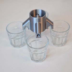 Könnte beinhalten: Ein silberner 3D-gedruckter Schnapsglas-Spender mit vier klaren Schnapsgläsern aus Glas.