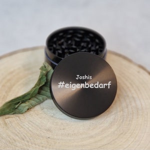 Puede incluir: Molino de metal negro con tapa negra. La tapa tiene el texto "Joshis #eigenbedarf" grabado.