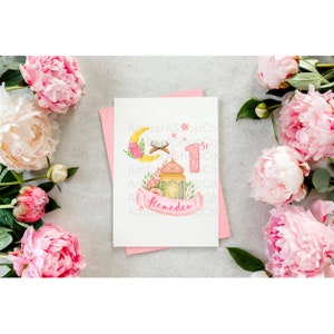 May include: A pink and white card with a crescent moon, a lantern, and a floral design. The card says "1st Ramadan".