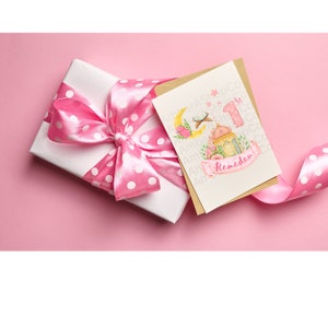 May include: A pink and white gift card with a watercolor illustration of a crescent moon, a lantern, and the text "1st Ramadan". The card is on a pink background with a white gift box wrapped in pink polka dot ribbon.