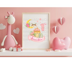 May include: A pink and yellow Ramadan themed printable with a crescent moon, a lantern, a prayer rug, and the number 1. The text "Ramadan" is on a pink ribbon.