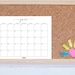 May include: A corkboard with a June 2023 calendar printed on white paper. The calendar is pinned to the corkboard with colorful sticky notes and a pink heart-shaped sticky note.