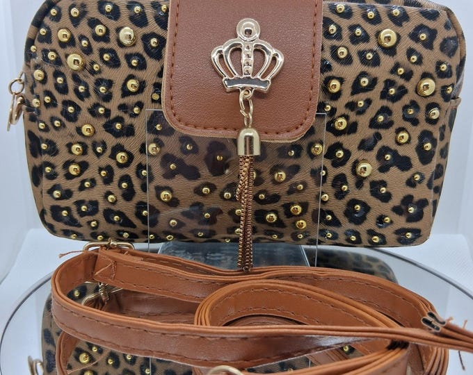 Leopard pattern crossbody handbag with gold studs and crown accessory