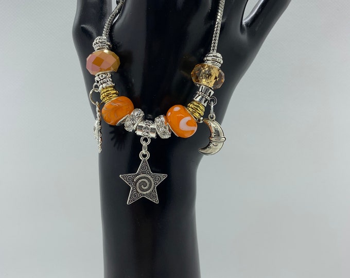 Bejeweled orange beaded bracelet w/ sun, star & moon charm