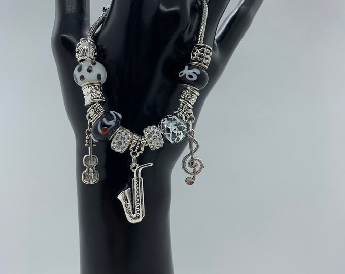 Bejeweled black beaded bracelet w/ musical note, violin & horn charm