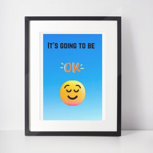 Może przedstawiać: Wydruk w ramie z niebieskim tłem i tekstem "It's going to be OK" w kolorze czarnym. Pod tekstem znajduje się żółta buźka z zamkniętymi oczami.