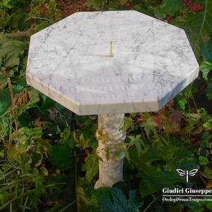 Reloj de sol horizontal en mármol y bronce dorado.