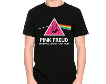 May include: Black t-shirt featuring a pink triangle with a portrait and rainbow design. The text "PINK FREUD" and "THE DARK SIDE OF YOUR MOM" are printed below the graphic. The shirt is a crew neck style.