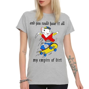 Op de afbeelding: Grijs T-shirt met een cartoonmuis die skateboardt en de tekst "and you could have it all my empire of dirt" in zwarte gotische letter.