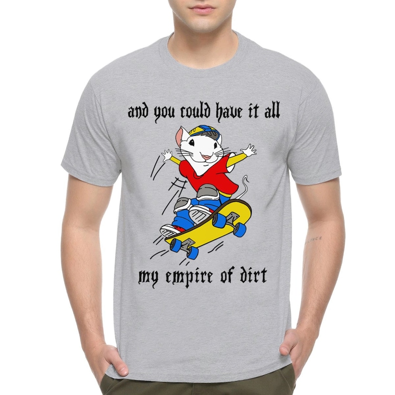 Op de afbeelding: Een grijs T-shirt met een cartoonmuis die skateboardt en de tekst "and you could have it all my empire of dirt".