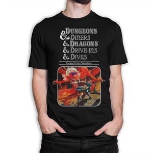 May include: Black t-shirt with a white graphic of a Dungeons & Diners & Dragons & Drive-Ins & Dives parody of the Dungeons & Dragons game cover. The graphic features a red dragon with sunglasses and a sword-wielding warrior.