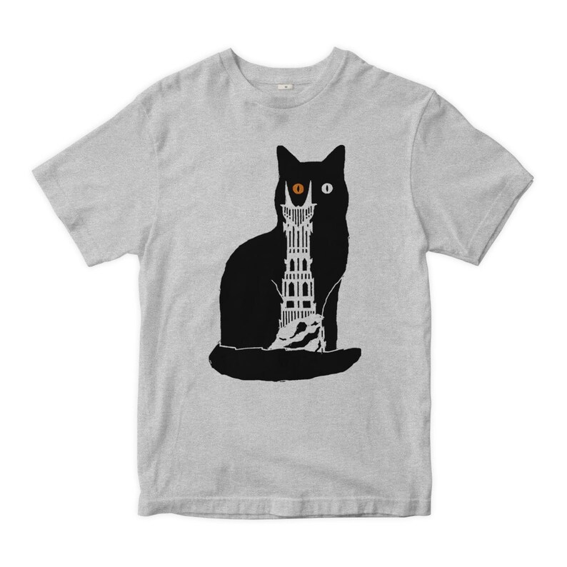 Puede incluir: Una camiseta gris con una silueta negra de un gato con una torre en su ojo. La torre tiene un solo ojo en la parte superior.