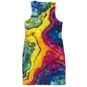 Op de afbeelding: Een mouwloze, bodycon jurk met een levendig tie-dye patroon. De jurk heeft een kleurrijk ontwerp met tinten geel, oranje, rood, paars, blauw en groen. De stof lijkt zacht en nauwsluitend, met een ronde hals.