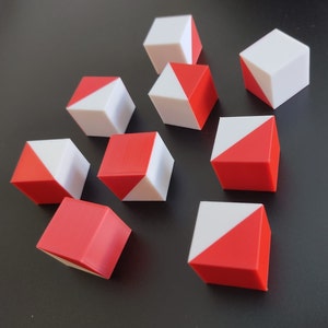 Puede incluir: Diez cubos rojos y blancos con una división diagonal. Cada cubo tiene una mitad roja y la otra mitad blanca.