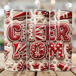 Puede incluir: Un vaso cilíndrico con pajita sobre un fondo color crema con el texto rojo CHEER MOM. El diseño incluye gráficos de megáfonos, estrellas y pompones en rojo y blanco con una apariencia texturizada en relieve y pequeños brillantes transparentes.