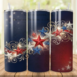 May include: Three stainless steel tumblers with lids and straws. Each tumbler features a patriotic design with red, white, and blue stars, swirls, and text from the Declaration of Independence. The tumblers are cylindrical and sit on a wooden surface.