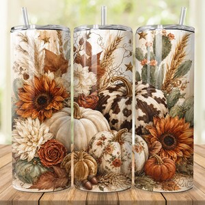 Peut inclure: Un gobelet cylindrique avec paille arborant un motif automnal composé de tournesols, de citrouilles blanches et orange, de blé séché et de cactus. Le design inclut une citrouille à motif vache marron et blanc et une autre avec des détails floraux.