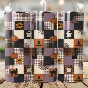 May include: Three stainless steel tumblers with a Halloween patchwork design. The design includes pumpkins, witch hats, ghosts, spiderwebs, and black cats. The tumbler has a straw and a lid. The background is a blurred image of a wooden table.