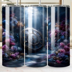 May include: A stainless steel tumbler with a wraparound design depicting an underwater scene. The design includes a large clock, coral, and aquatic plants in shades of blue, purple, and gold. The tumbler has a straw.