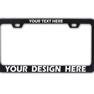 May include: Black license plate frame with white text that reads "YOUR TEXT HERE" at the top and "YOUR DESIGN HERE" at the bottom. The frame has a rectangular shape with rounded corners and mounting holes.