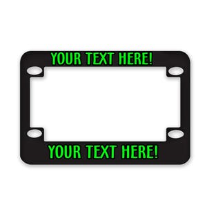 May include: Black license plate frame with the text "YOUR TEXT HERE!" in green. The frame has a rectangular shape with rounded corners and four mounting holes. The text is centered at the top and bottom.