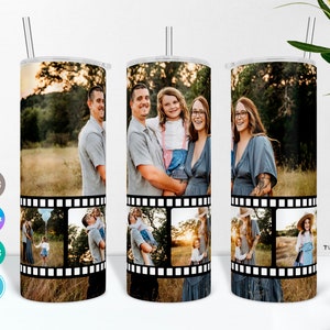 May include: A white tumbler with a black film strip design featuring photos of a family. The photos show a family of four in a field, a couple holding a baby, a woman holding a baby, and a girl standing in a field.