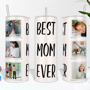 May include: White tumbler with a black inscription "BEST MOM EVER" and multiple photos of children. The tumbler has a straw.