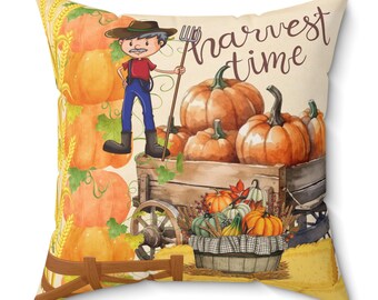 May include: A decorative throw pillow with a cartoon illustration of a farmer with a wagon full of pumpkins. The text "harvest time" is written in brown letters on the pillow.