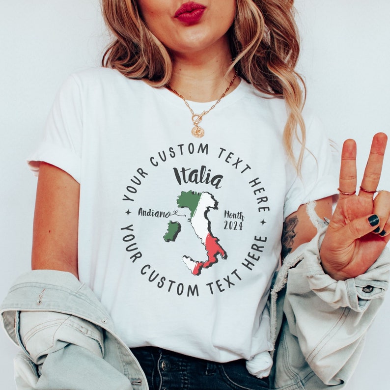 K&ouml;nnte beinhalten: Wei&szlig;es T-Shirt mit einem kreisf&ouml;rmigen Design mit dem Wort "Italia" und einer Karte von Italien in Gr&uuml;n, Wei&szlig; und Rot. Der Text "Your Custom Text Here" umgibt das Design. Das Shirt enth&auml;lt auch den Text "Andiamo" und "Month 2024".