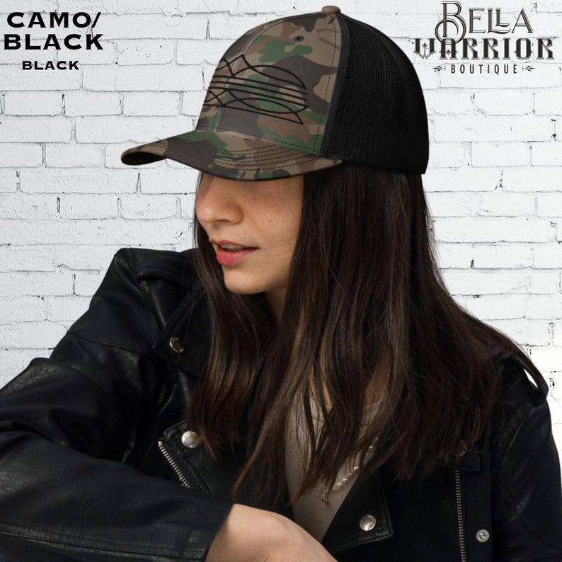 May include: A camo and black trucker hat with a black mesh back. The front panel features a camouflage pattern with a black graphic design. The text "CAMO/BLACK" and "BLACK" is printed on the left side of the hat. The hat is from Bella Warrior Boutique.