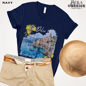 May include: Navy blue t-shirt featuring a watercolour illustration of a coastal Italian town with the text "Dolce Vita" and "Amalfi Coast, Italy".