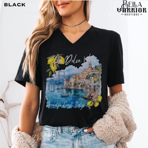 May include: Black v-neck t-shirt with a watercolour illustration of a coastal Italian town with the text "La Dolce Vita" and "Amalfi Coast Italy".