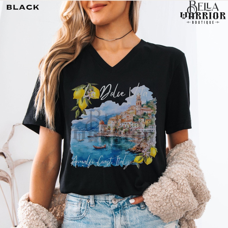 May include: Black v-neck t-shirt with a watercolour illustration of a coastal Italian town with the text "La Dolce Vita" and "Amalfi Coast Italy".
