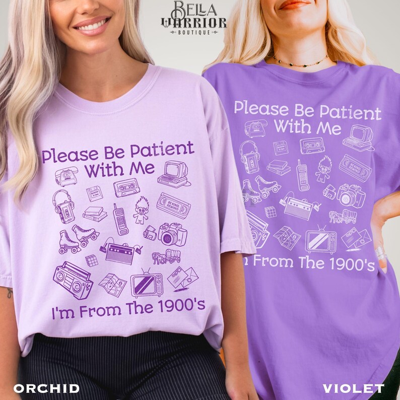 Puede incluir: Una camiseta de color violeta claro y una camiseta de color violeta, ambas con el texto "Please Be Patient With Me I'm From The 1900's" y varias ilustraciones de l&iacute;nea de objetos vintage como un reproductor de casetes, patines y televisi&oacute;n.